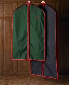 two green and black garment cases hanging on a wooden wall