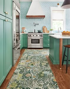 a kitchen with green cabinets and an area rug on the floor in front of the stove