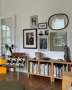 a living room filled with lots of furniture and pictures on the wall above it's bookshelf