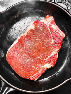 a piece of meat is cooking in a frying pan