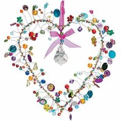 a heart shaped ornament with many different colored beads and charms on it's sides