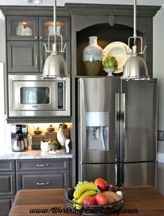 a kitchen with stainless steel appliances and fruit on the counter top in front of it