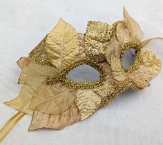 Gold eyemask decorated with gold organza, velvet and glitter leaves and gold trims. Ribbon ties. Flexible plastic base covered in felt on the inside for comfort.  Hand made in Australia. Laura Lucci's Collection. Gold Masquerade Eye Mask, Luxury Gold Masquerade Mask For Festivals, Luxury Gold Masquerade Mask, Gold Venetian Eye Mask For Masquerade, Red Masquerade Mask, Gold Baroque Masquerade Mask, Glitter Leaves, Ribbon Tie, Masquerade Mask