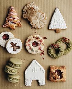 various cookies and pastries are arranged on a table top, including one cookie with an ornament in the shape of a christmas tree