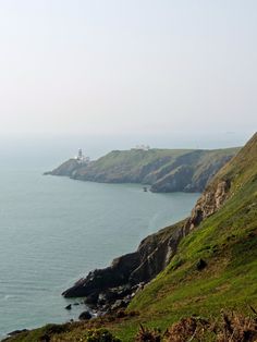 an ocean view with green grass and cliffs