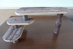 a wooden bench made out of two boards on top of a wood table next to a white wall