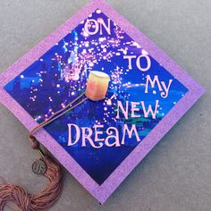 a purple graduation cap with the words on to my new dream written on it and a tassel