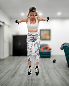 a woman jumping in the air with her arms outstretched