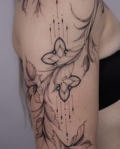 a woman's back with flowers and feathers on her left shoulder, which is drawn in black ink