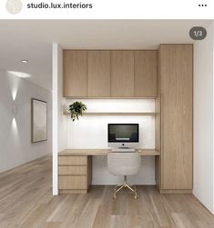 a computer desk with a monitor on top of it next to a wooden cabinet and white chair