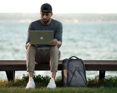 a man sitting on a bench with his laptop