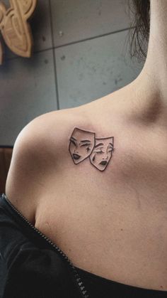 a woman with a tattoo on her chest has two faces in the shape of masks