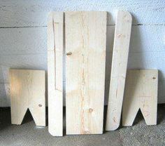 three pieces of wood sitting next to each other on the ground in front of a wall