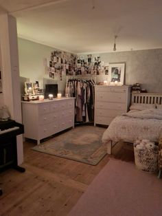 a bedroom with white furniture and pictures on the wall