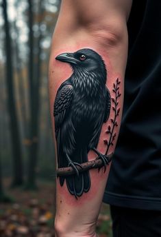 a black bird sitting on top of a branch with leaves around it's legs