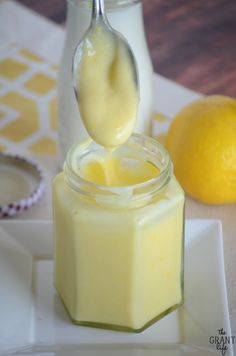 a spoon full of mayonnaise sitting on top of a jar filled with liquid