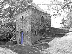 an old brick building with steps leading up to it and a blue door on the side