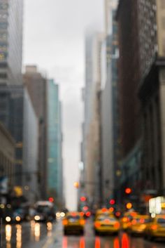 a city street filled with lots of traffic next to tall buildings and skyscrapers in the distance