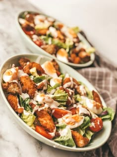 two plates filled with salad on top of a table