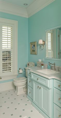 a bathroom with blue walls and white tile on the floor, along with two sinks