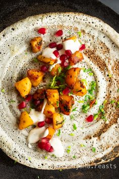 a tortilla topped with meat and pomegranates