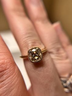 a close up of a person's hand with a ring on their finger and a diamond in the middle