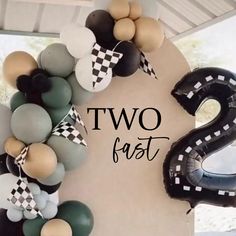 the number two is made out of balloons and some black and white checkered ribbons