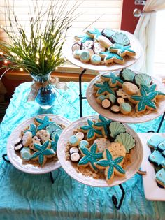 there are three trays that have cookies on them and one is decorated with starfish