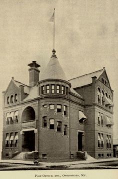 an old black and white photo of a building with a flag on the top of it