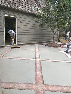 two men are working on a patio with cement