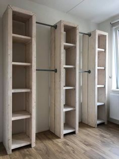 an empty room with three wooden shelves in it