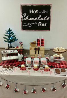 a table topped with cakes and cupcakes next to a sign that says hot chocolate bar