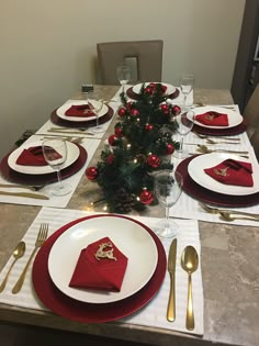 a christmas table setting with red and white place settings