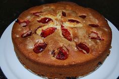 a cake with strawberries on top is sitting on a white plate, ready to be eaten