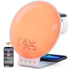 the alarm clock is on display next to an iphone and cell phone with it's charging dock