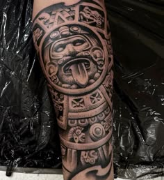 a man's leg with a tattoo on it that has an image of a tiki