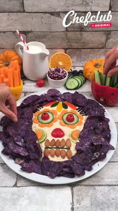 someone is cutting out pumpkin faces on a white plate with oranges and milk in the background