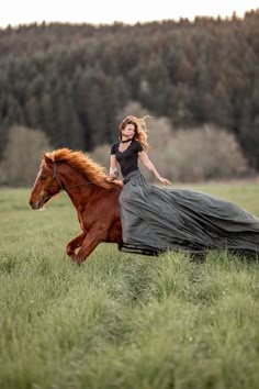 a woman riding on the back of a brown horse through a lush green grass covered field