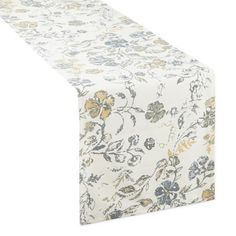 a white table runner with yellow and blue floral designs on it's edges, set against a white background