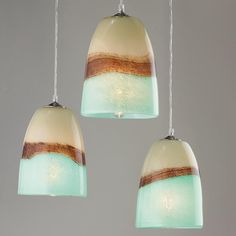 three hanging lights with different shades of green and brown