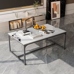 a coffee table with books and oranges on it