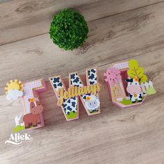 the word w is made out of wooden letters with farm animals and flowers on them