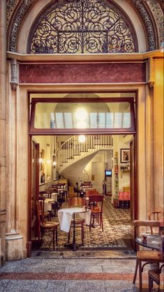 the entrance to an old building with tables and chairs in it's entryway