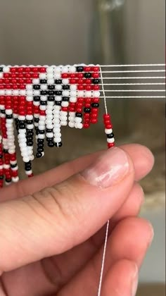 someone is holding a piece of beaded art that looks like an ornament