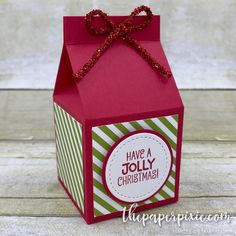 a red and green box with a bow on the top that says have a jolly christmas