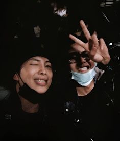 two people wearing face masks pose for the camera