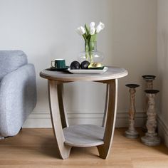 a small table with flowers on it next to a couch