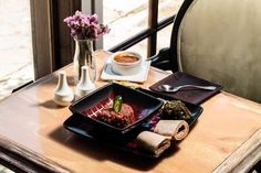 a table with some food on it next to a vase filled with flowers and other items