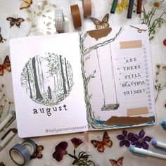 an open notebook with the words august written on it next to some scissors and other crafting supplies