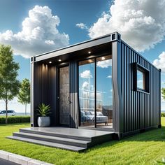 a black container home sitting on top of a lush green field in front of a blue sky